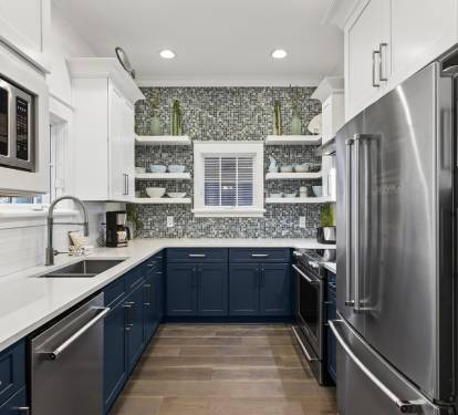Your gourmet kitchen awaits with gleaming appliances, stylish blue cabinets, and spacious counters perfect for creating memorable meals.