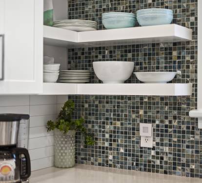 Your fully equipped kitchen features elegant open shelving with quality dishes and a stylish mosaic backsplash for your culinary adventures.
