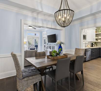 Gather around your elegant dining table beneath a stunning chandelier, with gleaming hardwood floors and an open kitchen perfect for entertaining.