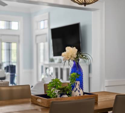Your elegant dining space features a beautiful wooden table and stylish centerpiece, with the bright living area just steps away for easy entertaining.