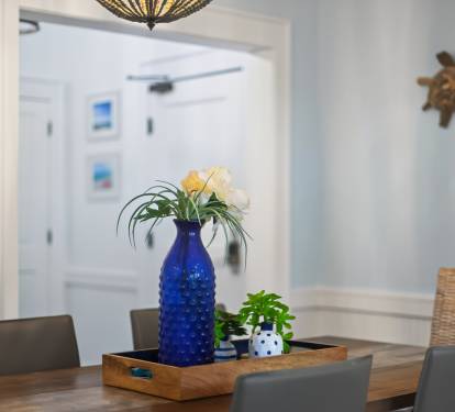 Your dining space welcomes you with coastal charm—fresh flowers and nautical touches create the perfect setting for memorable meals together.
