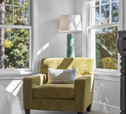 Settle into your cozy reading nook with natural light streaming through large windows, perfect for morning coffee moments.