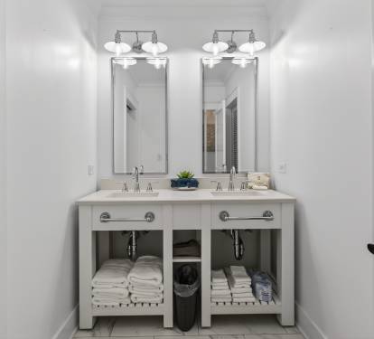 Step into your pristine bathroom featuring dual sinks and elegant mirrors, where fresh towels await your arrival.
