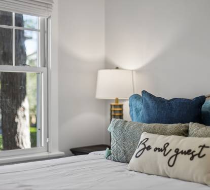 Sink into plush pillows and cozy textures in your beautifully appointed bedroom, where morning light streams through charming windows.