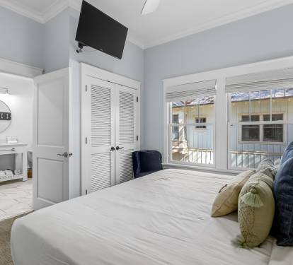 Drift off in this serene bedroom with crisp linens, en-suite bath, and charming windows overlooking peaceful surroundings.