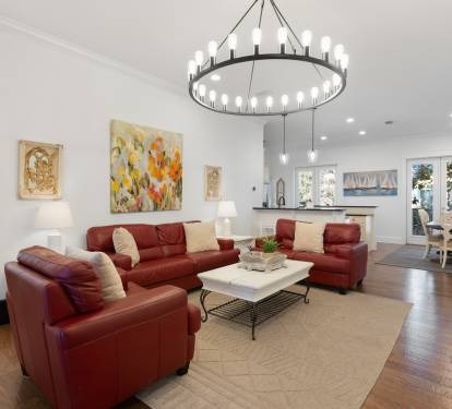Relax in your spacious open-concept living area with rich leather seating and stunning chandelier, creating the perfect space for memorable gatherings.