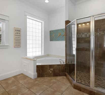 Unwind in your luxurious ensuite with a deep soaking tub and spacious walk-in shower featuring elegant tile work.