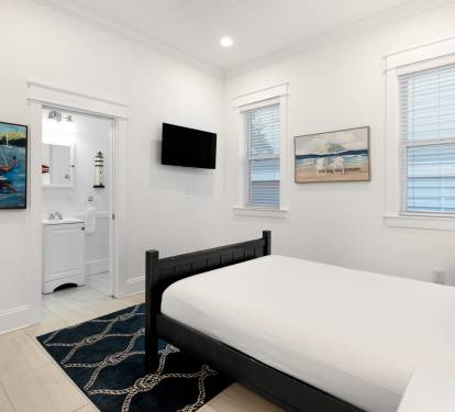 Drift off to sleep in your coastal-themed bedroom, where nautical artwork and crisp white linens create a serene retreat with modern conveniences.