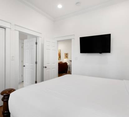Unwind in your serene bedroom with crisp white linens, modern TV for entertainment, and abundant storage for all your belongings.