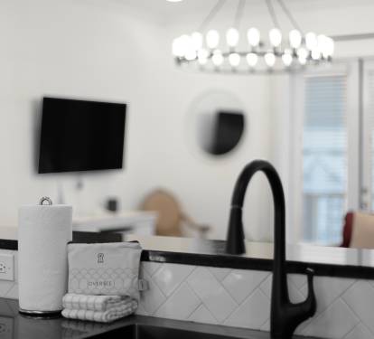 Enjoy your morning coffee in this bright, modern kitchen with sleek fixtures and stylish tile backsplash.