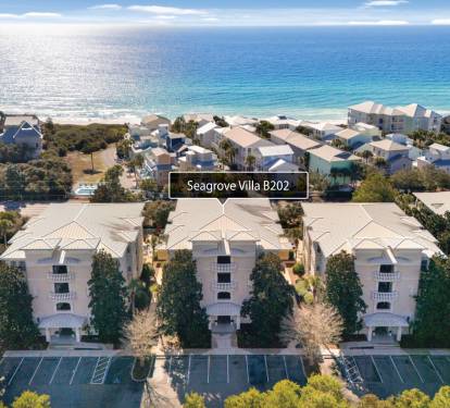 Aerial view of beachfront vacation rentals nestled among lush greenery, just steps from pristine white sand beaches and sparkling Gulf waters.