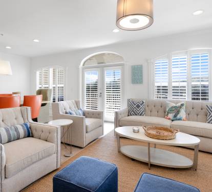 Sink into plush seating and enjoy natural light streaming through plantation shutters in your elegant living space.