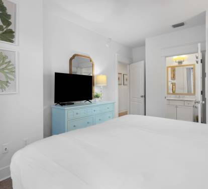Drift into peaceful sleep in your serene bedroom, featuring crisp white linens, charming coastal decor, and your own ensuite bathroom for ultimate comfort.