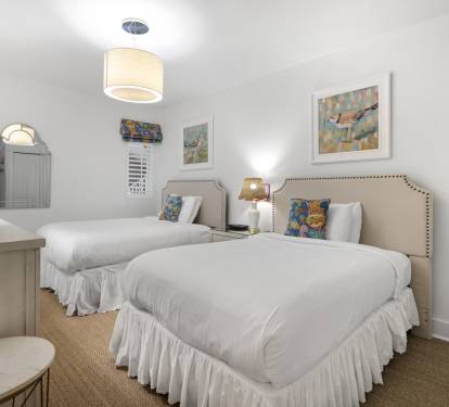 Relax in your bright twin bedroom with crisp linens, charming nautical artwork, and coastal-inspired decor creating a peaceful seaside retreat.
