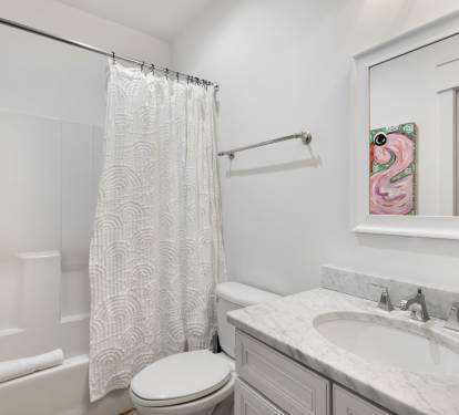Step into your pristine private bathroom with elegant marble counters, fresh towels, and a relaxing tub-shower combo.