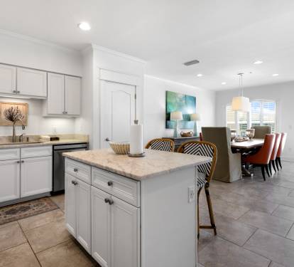 Your spacious kitchen flows seamlessly into the dining area, featuring elegant white cabinetry, modern appliances, and a convenient island for meal prep and casual dining.