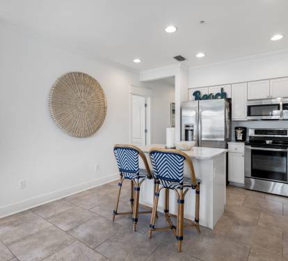 Your bright coastal kitchen awaits with stainless steel appliances, bar seating, and cheerful nautical touches for memorable meal prep.