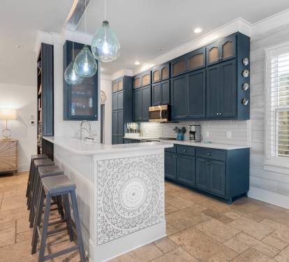 Your gourmet kitchen awaits with sleek navy cabinets, marble countertops, and pendant lighting creating the perfect space for culinary adventures.