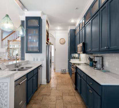 Your spacious galley kitchen features rich navy cabinets, marble countertops, and stainless appliances—perfect for preparing memorable meals together.