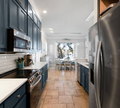 Cook memorable meals in your stylish galley kitchen, featuring sleek navy cabinets, stainless steel appliances, and bright subway tile backsplash.