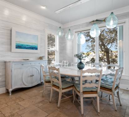 Gather around this charming dining table where coastal breezes flow through windows and sea-glass pendant lights create the perfect ambiance for your meals.