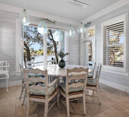 Gather around this charming dining table where coastal pendant lights cast a warm glow over your meals with stunning lake views.