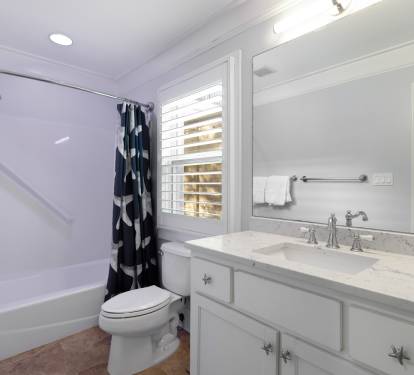 Your beautifully renovated bathroom features marble countertops, fresh white cabinetry, and a relaxing tub-shower combo for your comfort.