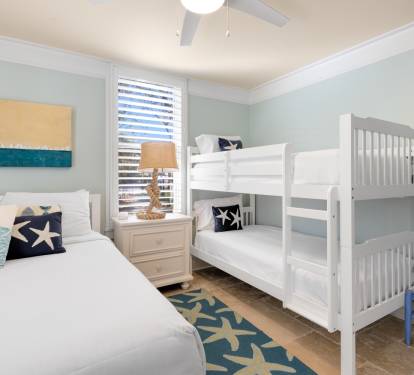 Your family bedroom features nautical-themed décor with bunk beds for the kids and comfortable seating.