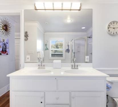 Unwind in your bright bathroom with dual vanities, perfect lighting, and charming coastal touches that make your morning routine a pleasure.