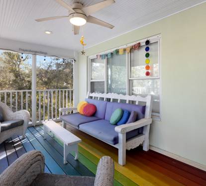 Relax on your private screened porch with colorful rainbow floors and cozy seating overlooking peaceful treetops.
