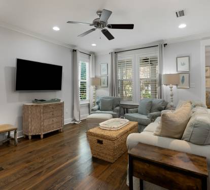 Sink into plush seating in your bright living room, where natural light floods through plantation shutters and a ceiling fan keeps you comfortable.
