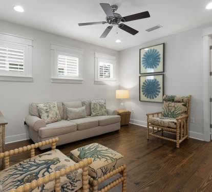 Relax in your bright coastal living room with comfortable seating, ceiling fan, and charming nautical touches throughout.