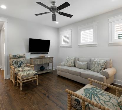 Your bright living room features coastal-inspired seating, flat-screen TV, and ceiling fan for perfect relaxation after beach days.
