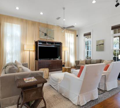 Unwind in your elegantly appointed living room with plush seating, warm hardwood floors, and natural light streaming through golden curtains.