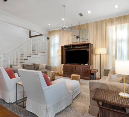 Relax in your elegant living room with plush seating, entertainment center, and warm natural light streaming through floor-to-ceiling windows.