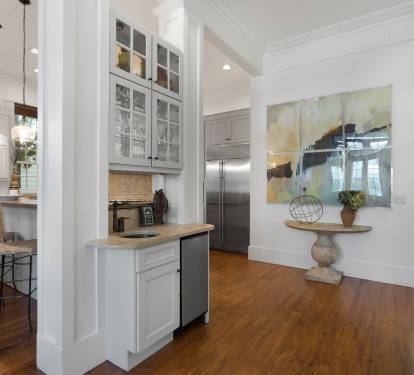 You'll love this bright, open kitchen with gleaming white cabinets, hardwood floors, and a charming breakfast bar perfect for morning coffee.