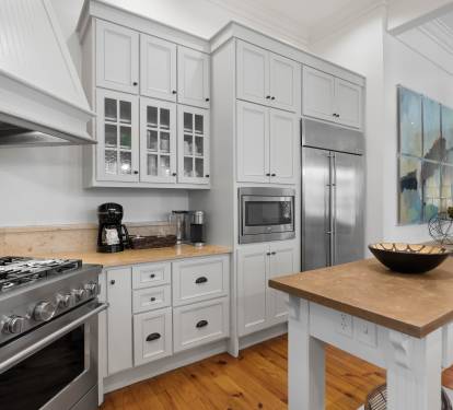 Your dream kitchen awaits with warm wood countertops, professional-grade appliances, and charming white cabinetry perfect for creating memorable meals.