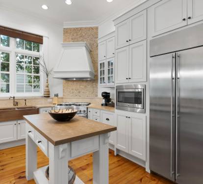 Your gourmet kitchen awaits with professional-grade appliances, butcher block island, and abundant natural light filtering through garden windows.