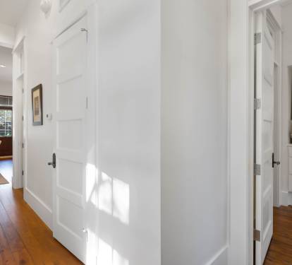Step into this bright, welcoming hallway where rich hardwood floors guide you through your spacious home away from home.