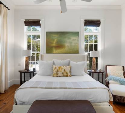 Your elegant bedroom features crisp white linens, warm hardwood floors, and natural light streaming through multiple windows for peaceful mornings.