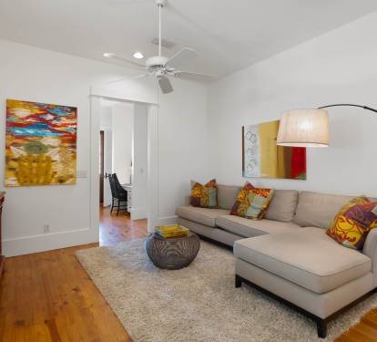 Relax in your stylish living room with vibrant art, plush sectional seating, and warm wood floors that create the perfect atmosphere.