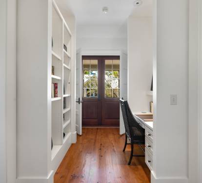Your private study nook features built-in shelving, warm wood floors, and French doors opening to garden views—perfect for quiet work.