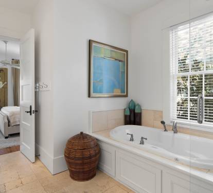 Unwind in your private spa-like bathroom, featuring a luxurious soaking tub perfectly positioned by the window for natural light and tranquil garden views.