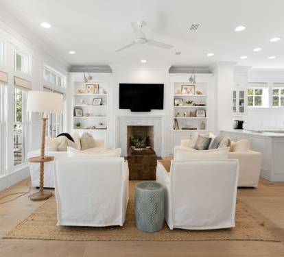 Sink into plush white seating while you watch your favorite shows by the fireplace in this bright, airy living space.