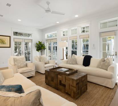 Relax in your bright living space with plush seating and French doors opening to outdoor views.