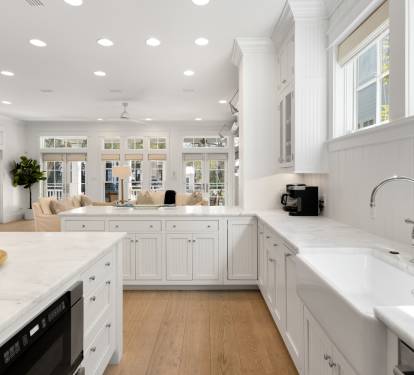 Your bright, elegant kitchen flows seamlessly into the living space, featuring pristine white cabinetry and expansive countertops perfect for cooking adventures.