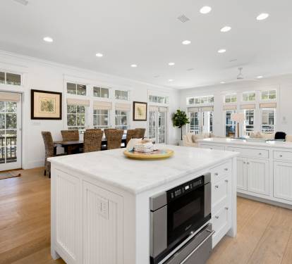 Gather around your bright kitchen island for meals and conversation, surrounded by sun-filled windows and elegant white cabinetry.