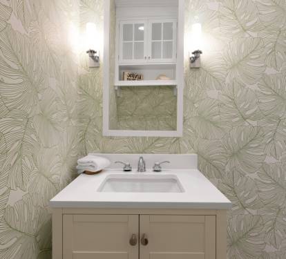 Fresh tropical wallpaper transforms your powder room into a stylish retreat with crisp white vanity and thoughtful details.