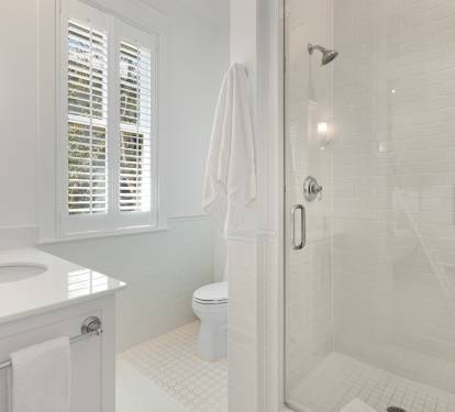 Step into your pristine bathroom featuring a spacious glass shower, crisp white finishes, and fresh towels waiting for your arrival.