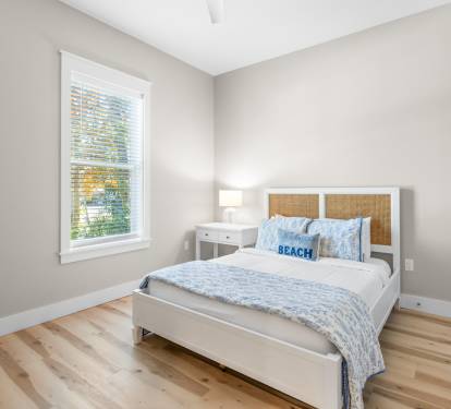 Wake up refreshed in your serene bedroom with natural light streaming through the window and soft coastal touches.